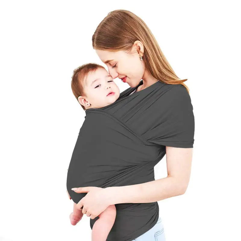 Mother carrying her baby in a black stretch wrap carrier